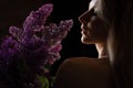 profile of a beautiful blonde woman with a bare shoulder and a bouquet of lilacs