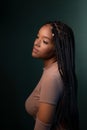 Profile of a beautiful young woman with braids in her hair, sitting Royalty Free Stock Photo