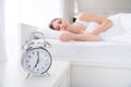 Profile blurry focus photo of charming lady lying sleeping bed white sheets blanket calm sure metal alarm clock will