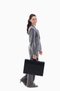 Profile of a business woman smiling and walking with a briefcase Royalty Free Stock Photo