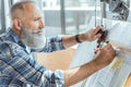 Pleasant serious old man is working on professional board Royalty Free Stock Photo