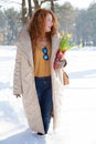 Profile of fashionable woman in warm clothes walking through snowdrifts