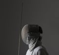 Profile of a fencer in fencing mask with the sword.Studio shot