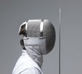 Profile of a fencer in fencing mask with the sword.Studio shot Royalty Free Stock Photo