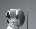 Profile of a fencer in fencing mask with the sword