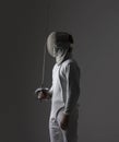 Profile of a fencer in fencing mask with the sword.Studio shot