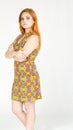 Profile of girl with arms crossed. Redheaded girl wearing colorful yellow dress. Summer..