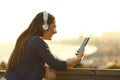 Girl listening music on phone with headphones at sunset Royalty Free Stock Photo