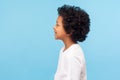 Profile of happy little boy with curly hair in T-shirt smiling carefree and looking to side copy space Royalty Free Stock Photo