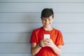 Profile of a happy male teen texting on a smart phone Royalty Free Stock Photo