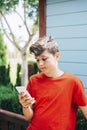 Profile of a happy male teen texting on a smart phone Royalty Free Stock Photo