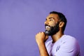 profile headshot of a handsome smiling african american man with beard and mustache purple shirt looking away at copy Royalty Free Stock Photo