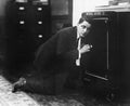 Profile of a man opening the door of a safe