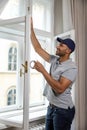 Profile of man putting sealing foam tape on window indoors insulating his house. Royalty Free Stock Photo