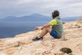 Profile of a man sitting in the wind on a steep seashore on the southern coast of Crete, Greece