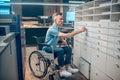 Profile of man in wheelchair touching in handle of drawer