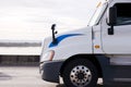 Profile of modern white semi truck going on the road in sunshine