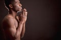 Profile of nacked black male holding palms together is worshiping God