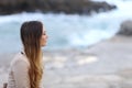 Profile of a pensive woman on the beach in winter