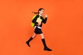 Profile photo of active schoolgirl jump hold book run wear uniform backpack isolated orange color background
