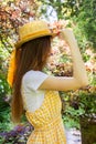 Profile photo of a brunette girl in a wicker straw hat with a ribbon in the park