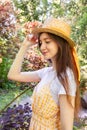 Profile photo of a brunette girl in a wicker straw hat with a ribbon in the park