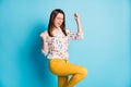 Profile photo of cute young girl raise fist knee wear spectacles geometry print shirt yellow pants isolated blue color