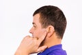 Profile photo of a deaf man with a hearing aid device in ear on a white background. Enlarged photo.