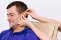 Profile photo. Female hands dress a hearing aid to a man on a white background. Health support for disabled people