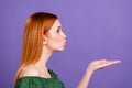 Profile photo of flirty ginger hair young lady blow kiss wear green open shoulders blouse isolated on violet color