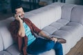 Profile photo of handsome guy holding telephone near ear listening foreign friend chatterbox cosy sit sofa in living Royalty Free Stock Photo