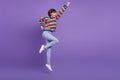 Profile photo of hero confident lady jump raise fist wear striped sweater jeans shoes isolated purple color background