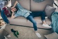 Profile photo of hipster crazy guy lying sofa holding head intoxicated food underwear bottles lying floor had stag party Royalty Free Stock Photo