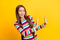 Profile photo of little disgusted girl raise two arms show denial wear striped shirt isolated yellow color background