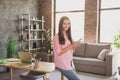 Profile photo of optimistic brunette lady hold telephone sit on table wear pink shirt jeans study from home Royalty Free Stock Photo