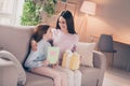 Profile photo of optimistic brunette red hairdo mom daughter hold gift paper sit on sofa wear sweater pants at home Royalty Free Stock Photo