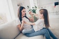 Profile photo of pretty little girl young charming mommy holding arms hands having fun swinging sitting comfy sofa spend