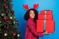 Profile photo of sad millennial brunette lady hold present look tree wear horns red nightwear isolated on blue color