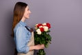 Profile photo of sale manager lady holding big bunch of roses delivering it to clients house wear jeans shirt covered by Royalty Free Stock Photo