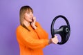 Profile photo of scared lady driver hold steering wheel bite nail wear orange jumper purple color background