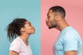 Profile photo of young black spouses reaching to each other and trying to kiss, isolated over pink and blue background