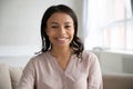 Headshot portrait of smiling biracial woman posing at home