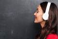 Profile of Pleased brunette woman in red blouse and headphones