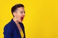 Profile portrait angry upset woman screaming crying wide open mouth hysterical face grimace isolated yellow wall background. Royalty Free Stock Photo