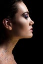 profile portrait of attractive glamorous woman posing with makeup and glitter on body