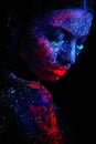 Profile portrait of a beautiful girl alien. Ultraviolet body art blue night sky with stars and pink jellyfish