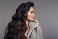 Profile portrait of Beautiful woman with hood in mink fur coat isolated on gray studio background. Fashion Brunette Girl in Luxury Royalty Free Stock Photo