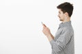 Profile portrait of carefree happy caucasian boyfriend with moustache and beard, holding smartphone, looking at screen