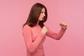 Profile portrait concentrated brunette woman holding clenched fists up, fighting with abuser, defence from domestic violence