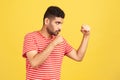 Profile portrait concentrated serious man with beard in striped t-shirt holding clenched fists up ready to boxing, punching with